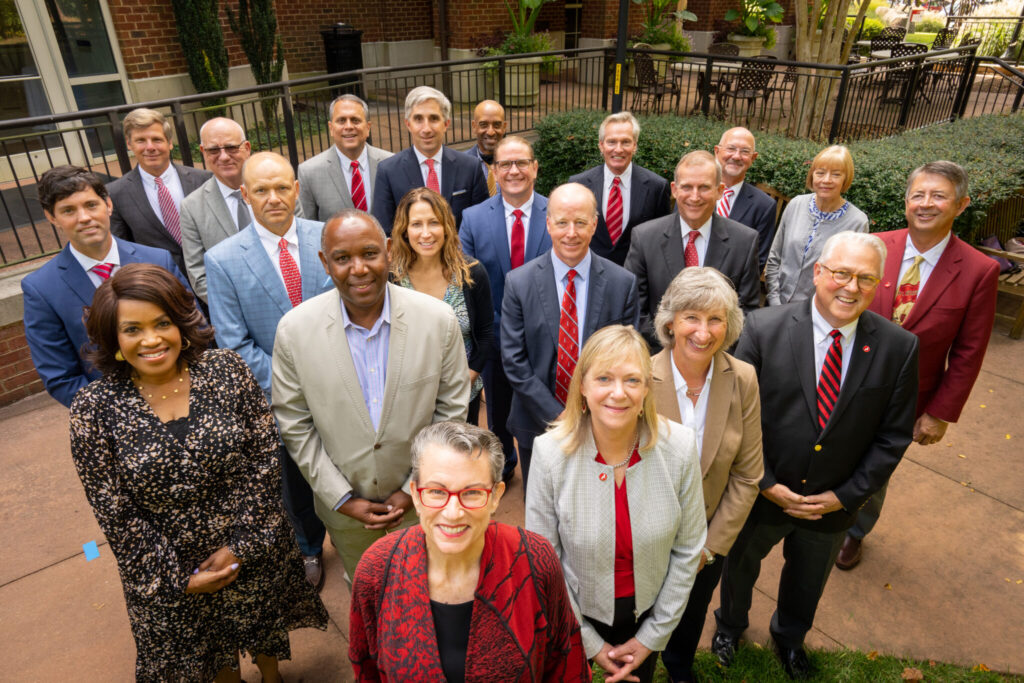 Board of Visitors members standing together with Chancellor Woodson for a photo.
